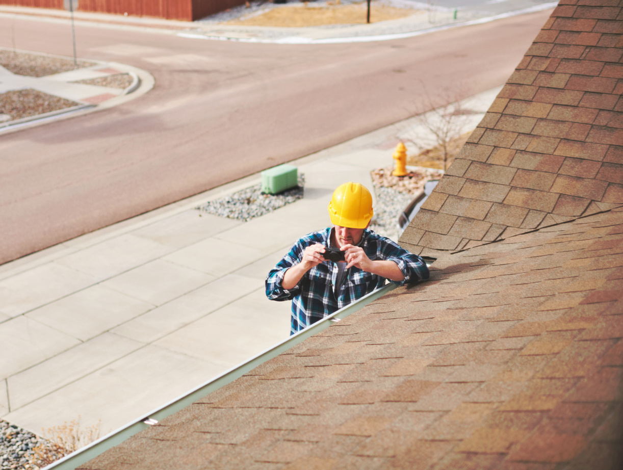 Home Appraiser or Home Inspector surveying roof of property